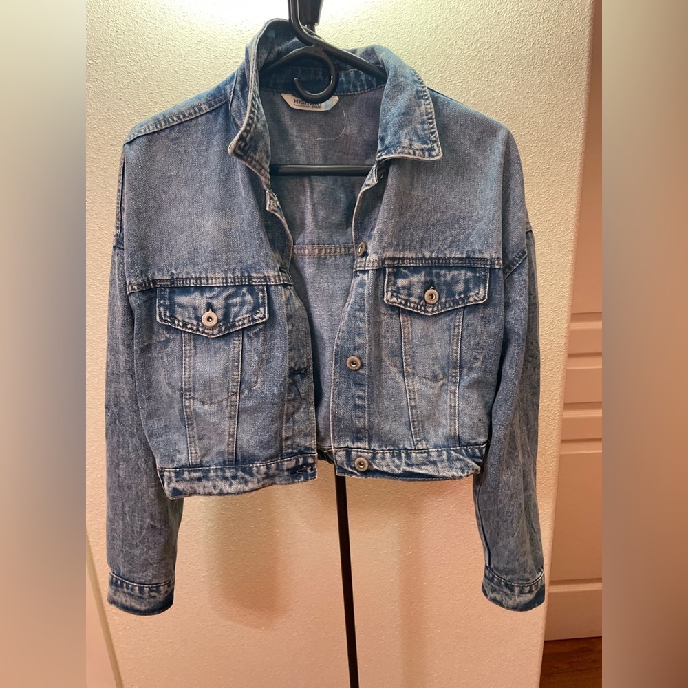 Jean jacket with angel wings painted on the back.
